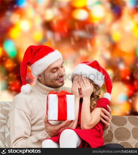 family, christmas, x-mas, winter, happiness and people concept - smiling daughter with closed eyes waiting for a present from fathe