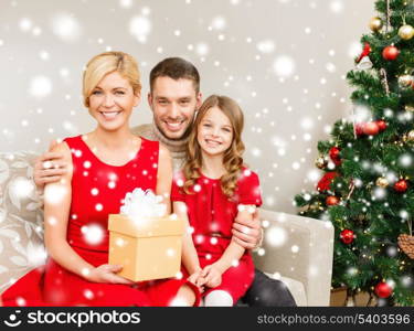 family, christmas, x-mas, winter, happiness and people concept - smiling family at home with gift box