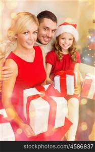 family, christmas, x-mas, winter, happiness and people concept - smiling family in santa helper hats with many gift boxes