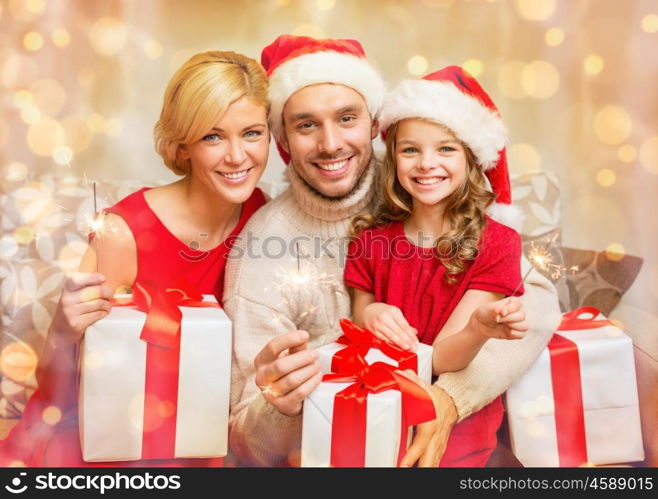 family, christmas, x-mas, winter, happiness and people concept - smiling family in santa helper hats with many gift boxes and bengal lights