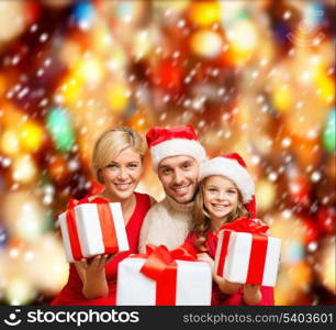 family, christmas, x-mas, winter, happiness and people concept - smiling family in santa helper hats with many gift boxes