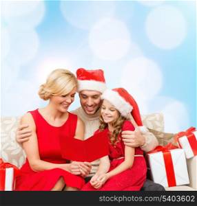 family, christmas, x-mas, winter, happiness and people concept - smiling family in santa helper hats with many gift boxes reading postcard