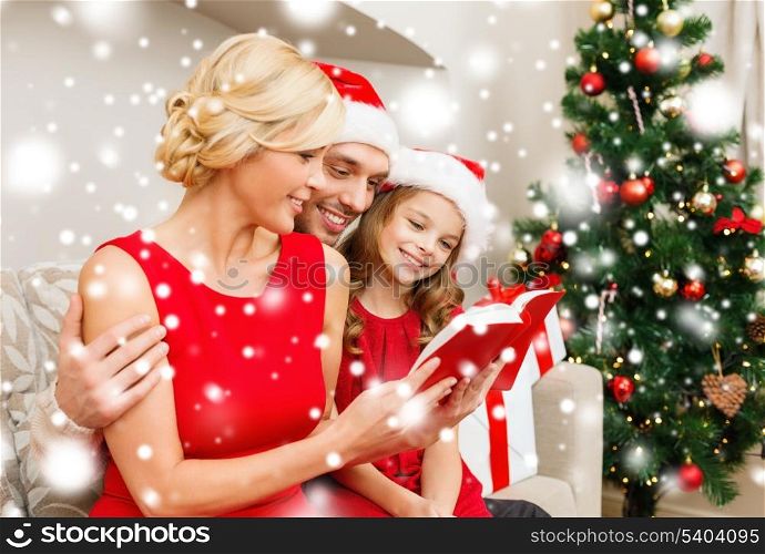 family, christmas, x-mas, winter, happiness and people concept - smiling family in santa helper hats with many gift boxes reading book
