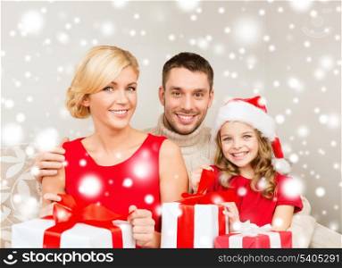 family, christmas, x-mas, winter, happiness and people concept - smiling family in santa helper hats with many gift boxes