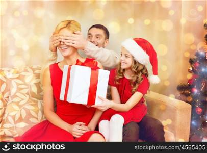 family, christmas, x-mas, winter, happiness and people concept - smiling father and daughter surprise mother with big gift box