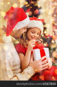 family, christmas, x-mas, winter, happiness and people concept - smiling father and daughter in santa helper hats opening gift box