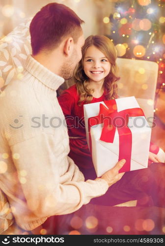 family, christmas, x-mas, winter, happiness and people concept - smiling father and daughter holding gift box and looking at each other