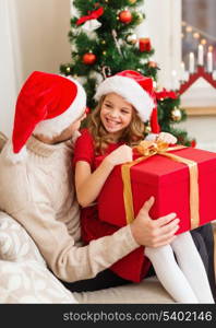 family, christmas, x-mas, winter, happiness and people concept - smiling father and daughter in santa helper hats opening gift box