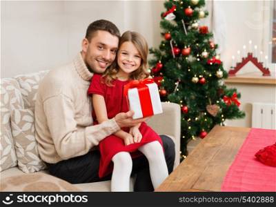 family, christmas, x-mas, winter, happiness and people concept - smiling father and daughter holding gift box