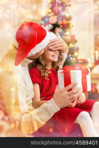 family, christmas, x-mas, winter, happiness and people concept - smiling father surprise daughter with gift box covering eyes with hand