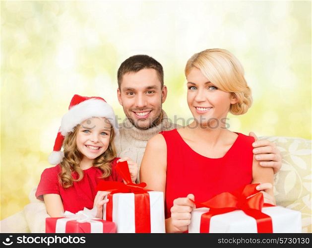 family, christmas, xmas, happiness and people concept - smiling family in santa helper hats with many gift boxes