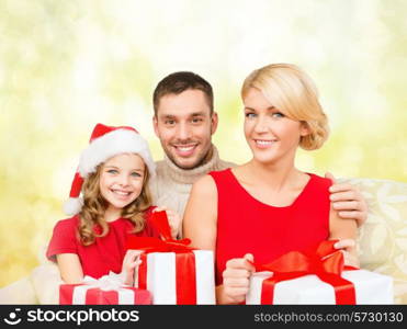 family, christmas, xmas, happiness and people concept - smiling family in santa helper hats with many gift boxes