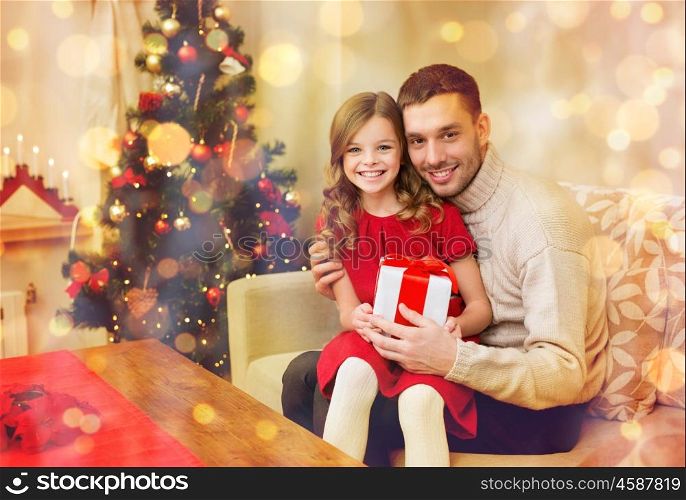 family, christmas, xmas, happiness and people concept - smiling father and daughter holding gift box