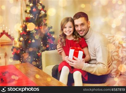 family, christmas, xmas, happiness and people concept - smiling father and daughter holding gift box