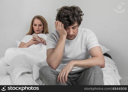 Family conflict concept. Family conflict concept, addicted to cellphone woman and upset man on bed