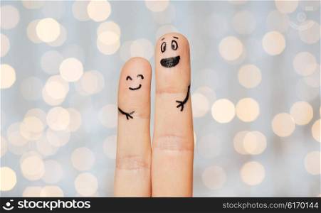 family, couple, people and body parts concept - close up of two fingers with smiley faces over holidays lights background