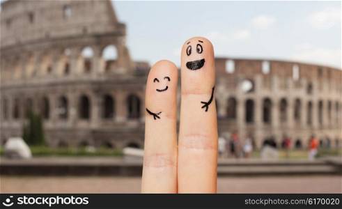 family, couple, travel, tourism and body parts concept - close up of two fingers with smiley faces over coliseum in rome background