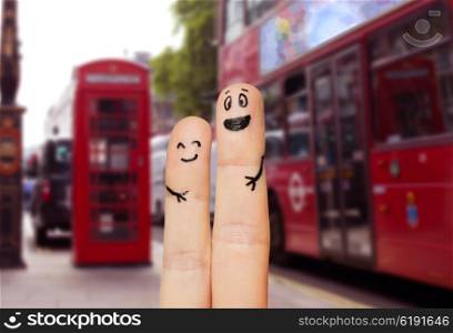 family, couple, travel, tourism and body parts concept - close up of two fingers with smiley faces over london city street background