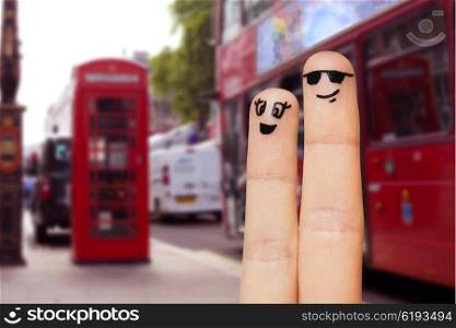 family, couple, travel, tourism and body parts concept - close up of two fingers with smiley faces over london city street background