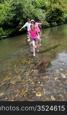 Family crossing river barefoot
