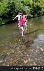 Family crossing river barefoot