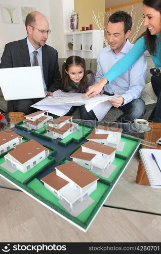 Family discussing a housing development with an architect