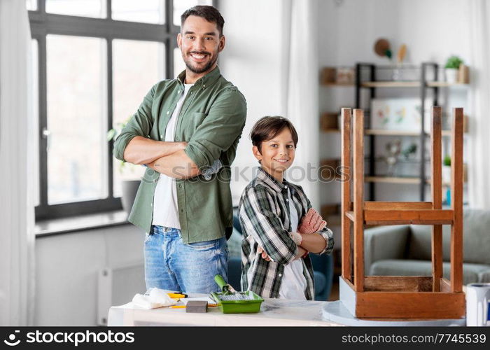 family, diy and home improvement concept - happy smiling father and son with ruler restoring old table. father and son restoring old table at home