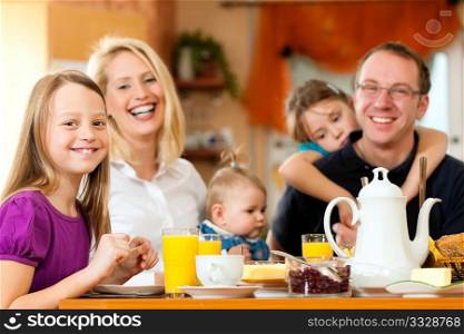 Family eating breakfast in the kitchen of their house