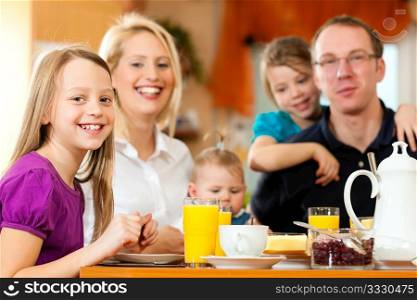 Family eating breakfast in the kitchen of their house