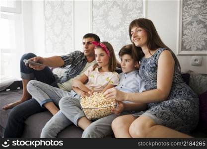 family eating popcorn during watching television home