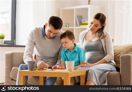 family, education and pregnancy concept - father, pregnant mother and little son drawing at home. father, pregnant mother and son drawing at home