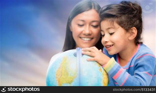 family, education, travel and people concept - mother and daughter with globe over evening sky background. happy mother and daughter with globe over sky. happy mother and daughter with globe over sky