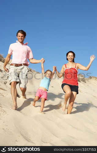 Family Enjoying Beach Holiday Running Down Dune