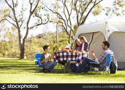 Family Enjoying Camping Holiday In Countryside