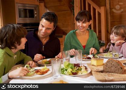 Family Enjoying Meal In Alpine Chalet Together
