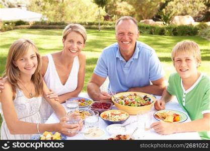 Family Enjoying Meal In Garden