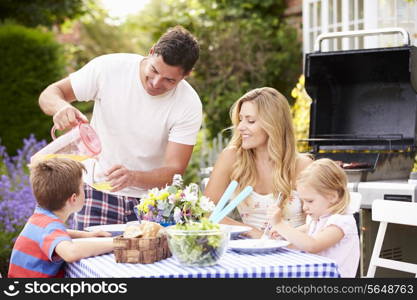 Family Enjoying Outdoor Barbeque In Garden