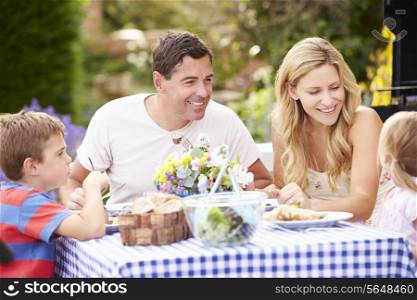 Family Enjoying Outdoor Meal In Garden