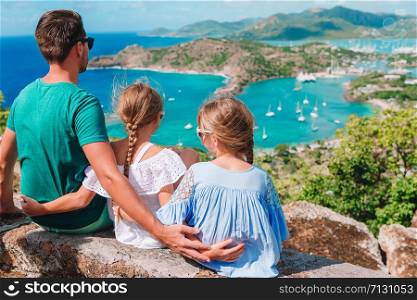 Family enjoying the view of picturesque English Harbour at Antigua. View of paradise bay at tropical island in the Caribbean Sea. Family vacation.. View of English Harbor from Shirley Heights, Antigua, paradise bay at tropical island in the Caribbean Sea
