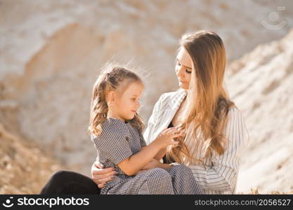 Family entertainment in nature among the sands.. Mom plays with her daughter in nature among the sands 3361.