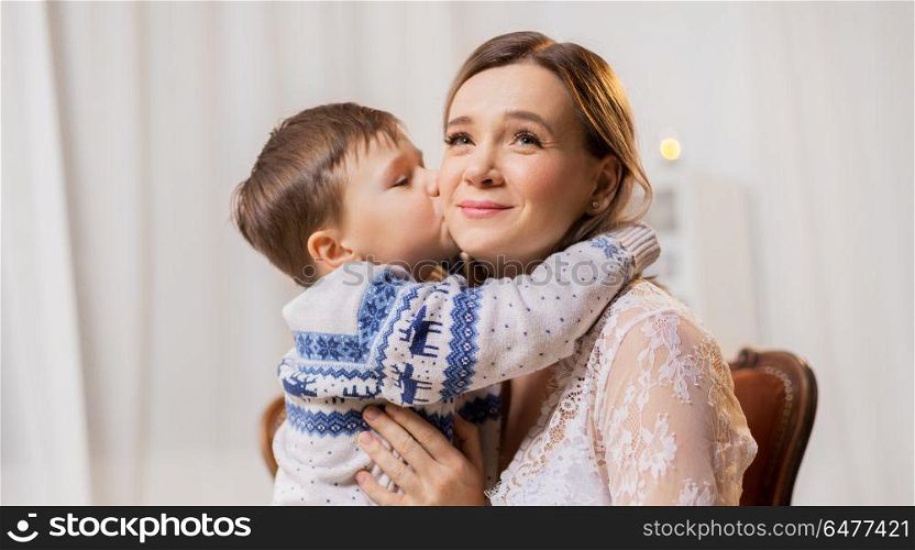 family, expressions and love concept - happy little son kissing his mother. happy little son kissing his mother. happy little son kissing his mother