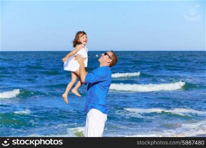 Family father holding daughter playing on the beach shore