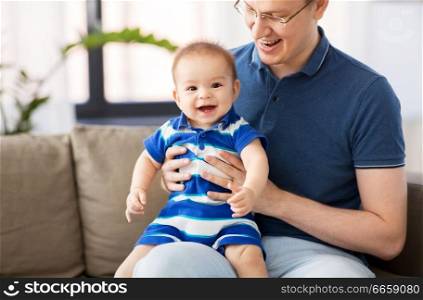 family, fatherhood and childhood concept - happy father with baby son at home. happy father with baby son at home