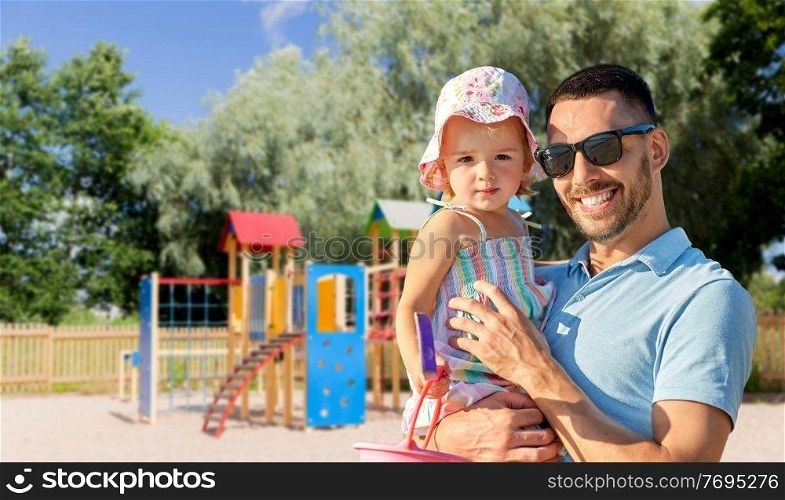 family, fatherhood and leisure concept - happy smiling father with little daughter on children&rsquo;s playground on background. happy father with little daughter on playground
