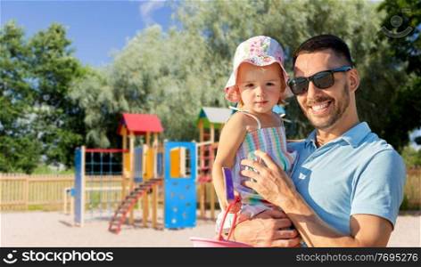 family, fatherhood and leisure concept - happy smiling father with little daughter on children&rsquo;s playground on background. happy father with little daughter on playground