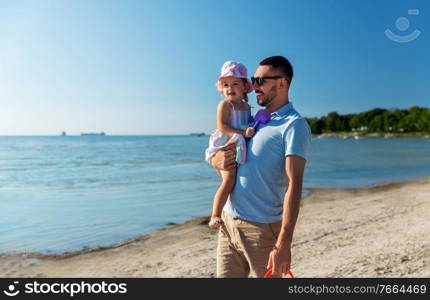 family, fatherhood and leisure concept - happy smiling father with little daughter on beach. happy father with little daughter on beach