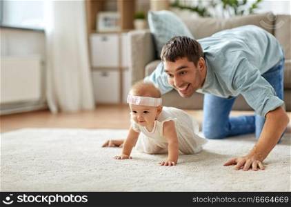 family, fatherhood and parenthood concept - happy little baby girl with father at home crawling on floor. happy little baby girl with father at home