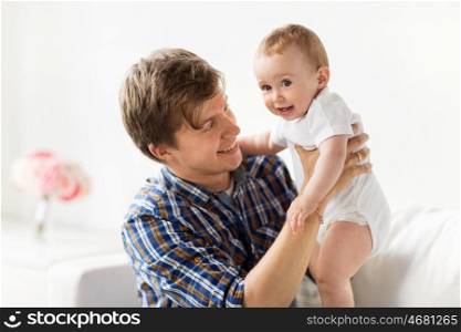 family, fatherhood and parenthood concept - happy smiling young father with little baby at home