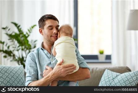family, fatherhood and people concept - father with little baby daughter at home. father with little baby daughter at home