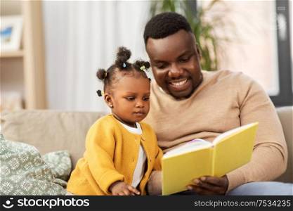 family, fatherhood and people concept - happy african american father reading book for baby daughter at home. african father reading book for baby daughter